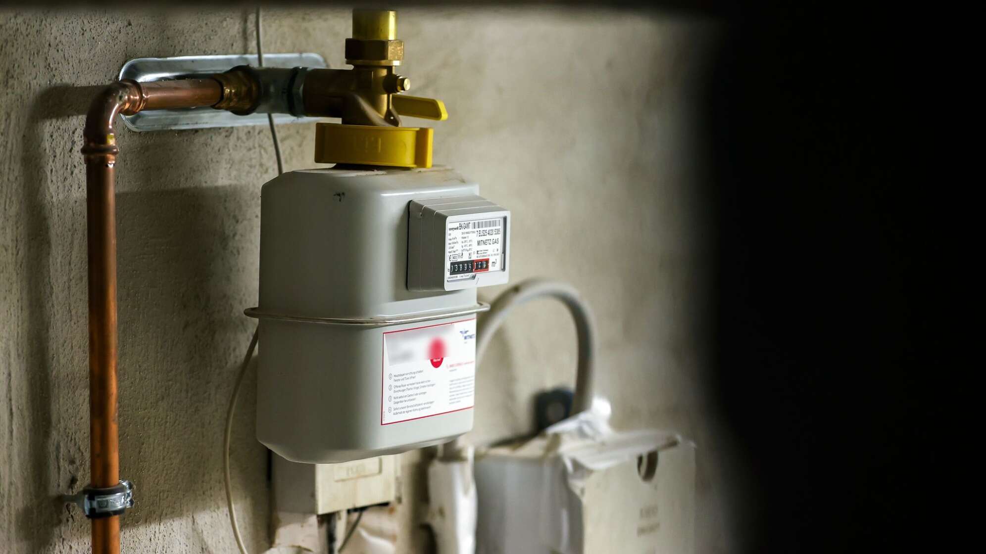 Gaszähler hängt im Keller eines Einfamilienhauses