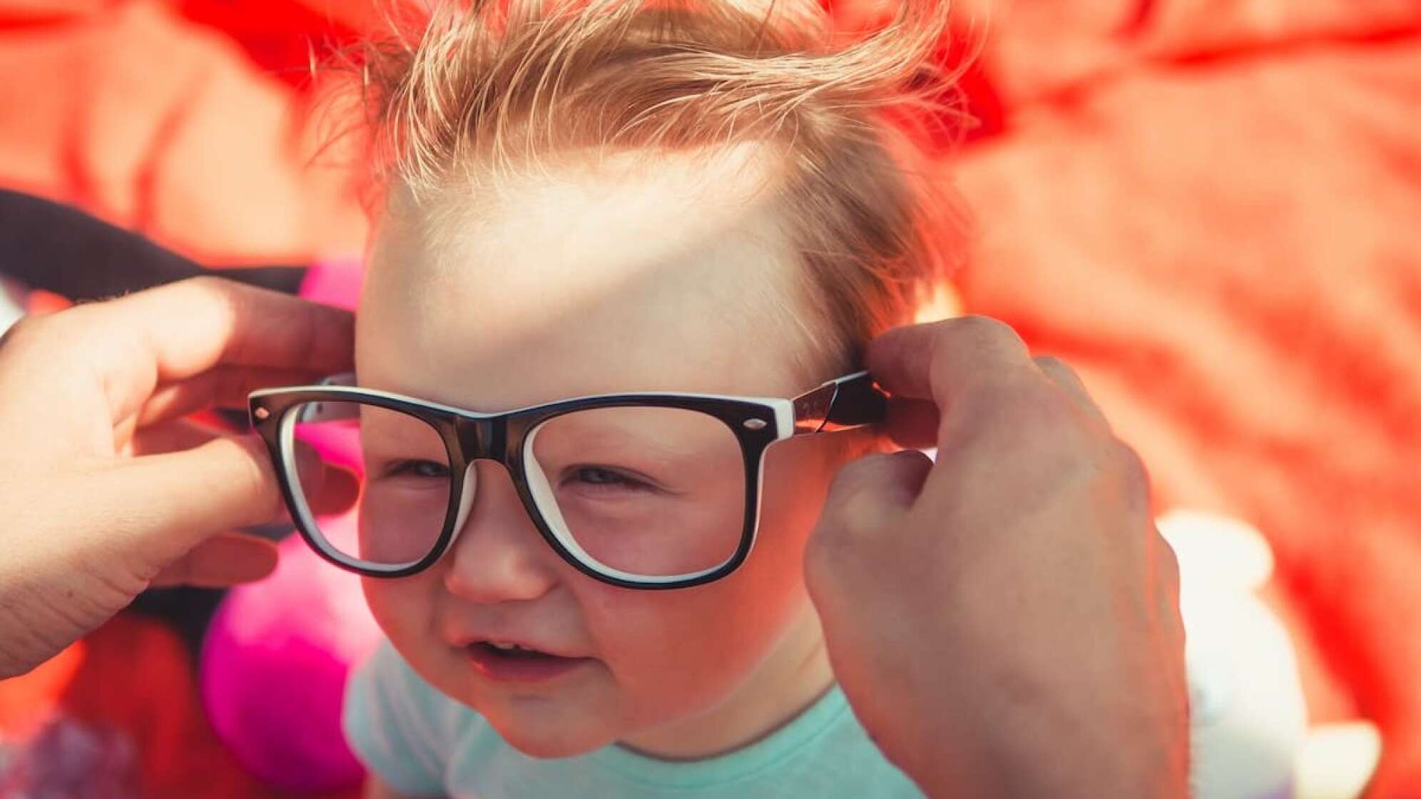 Kleinkind wird eine Brille aufgesetzt