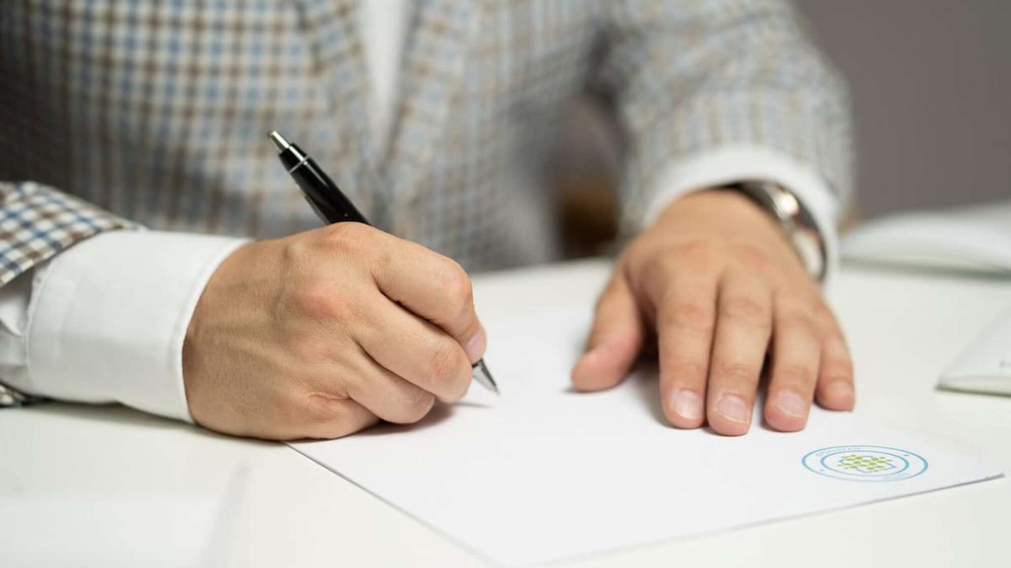 Mann unterschreibt ein Dokument