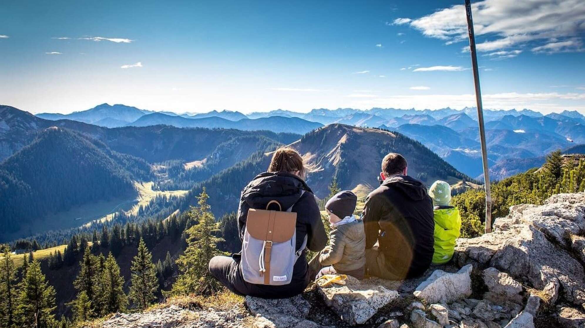 Familie sitzt auf Berg