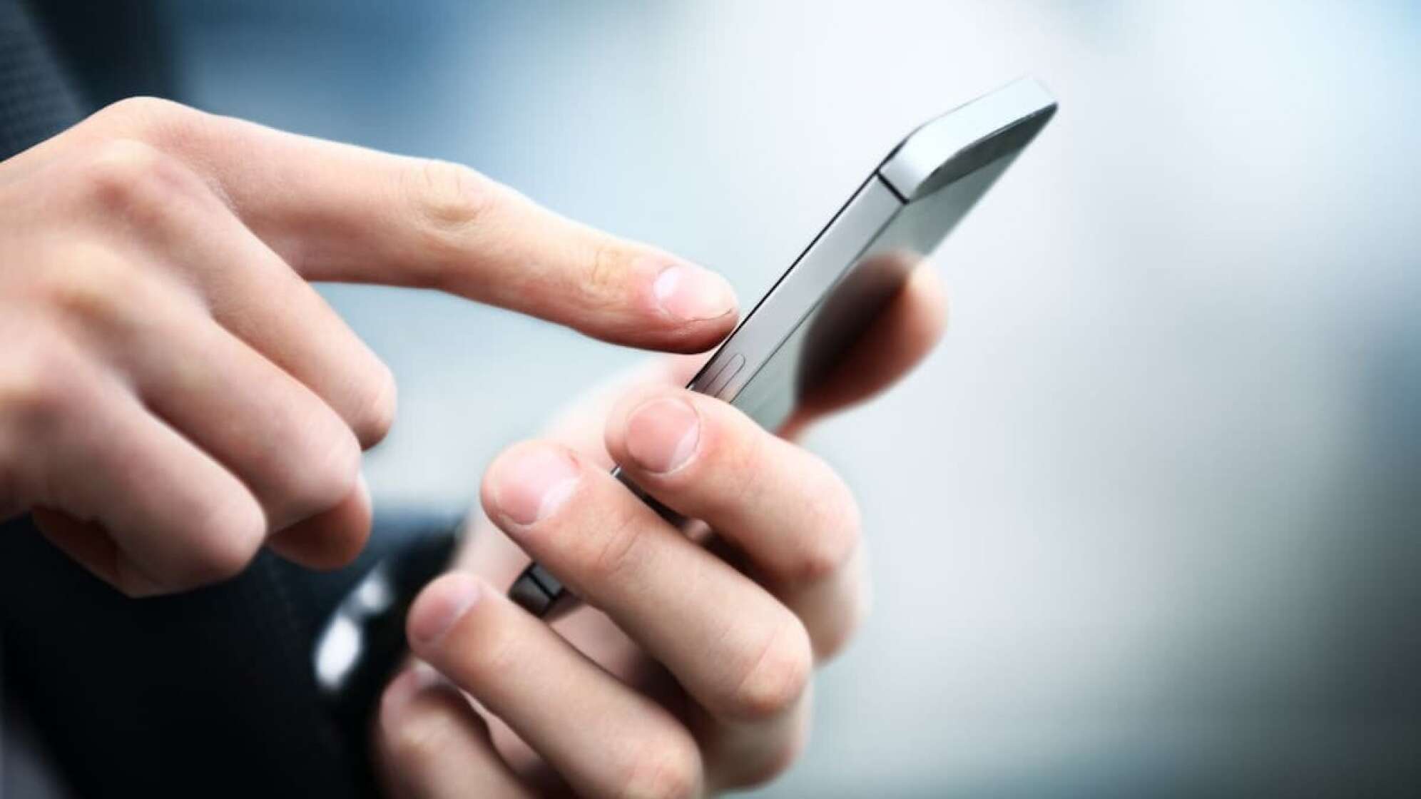 Mann tippt in ein Handy