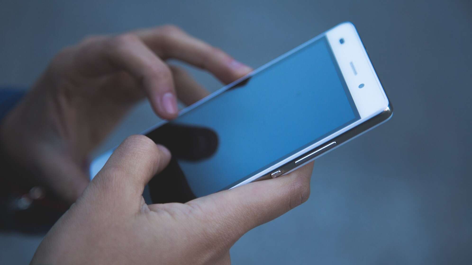 Mann tippt sein Handy