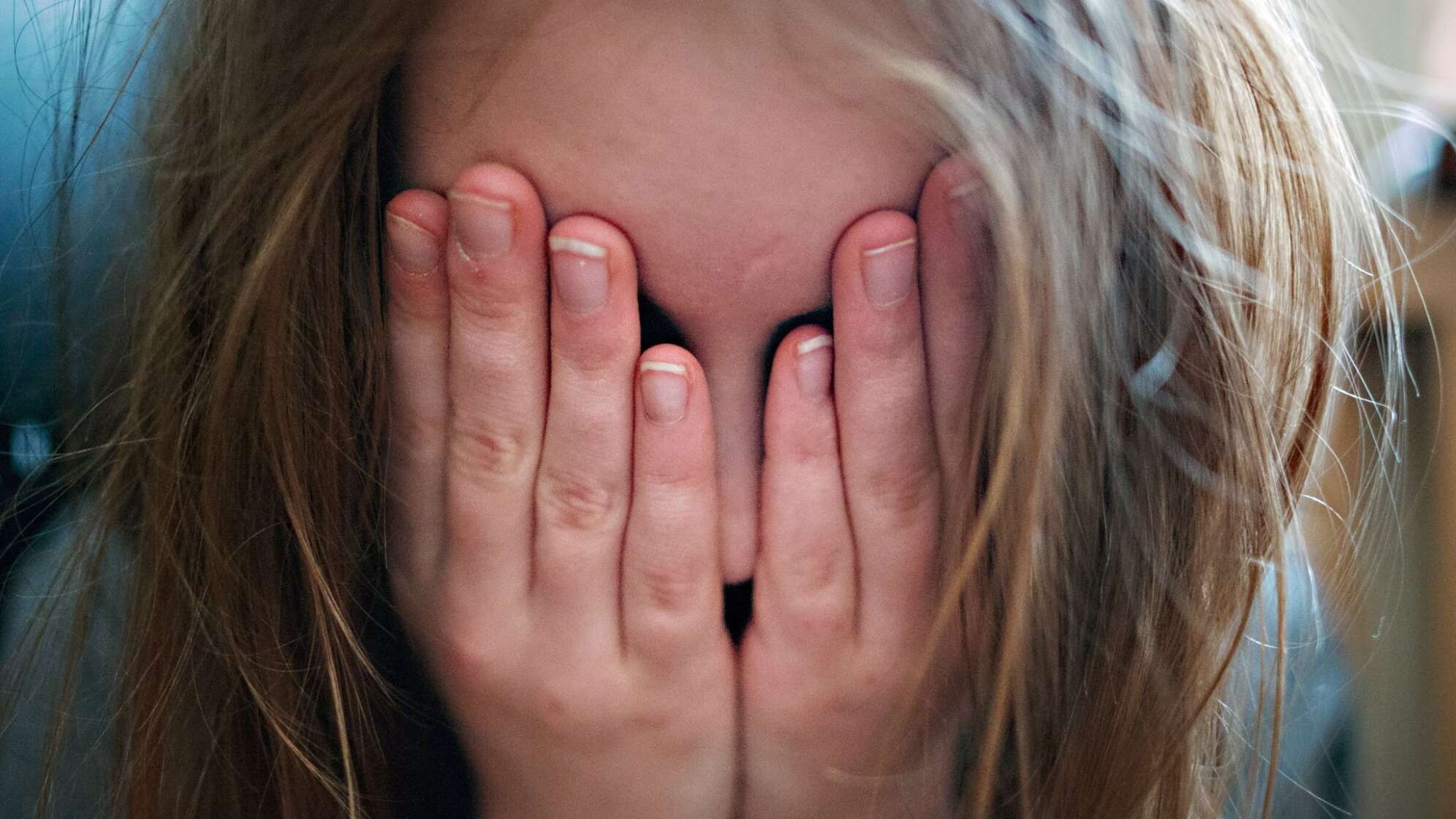 Kind hält sich die Augen zu