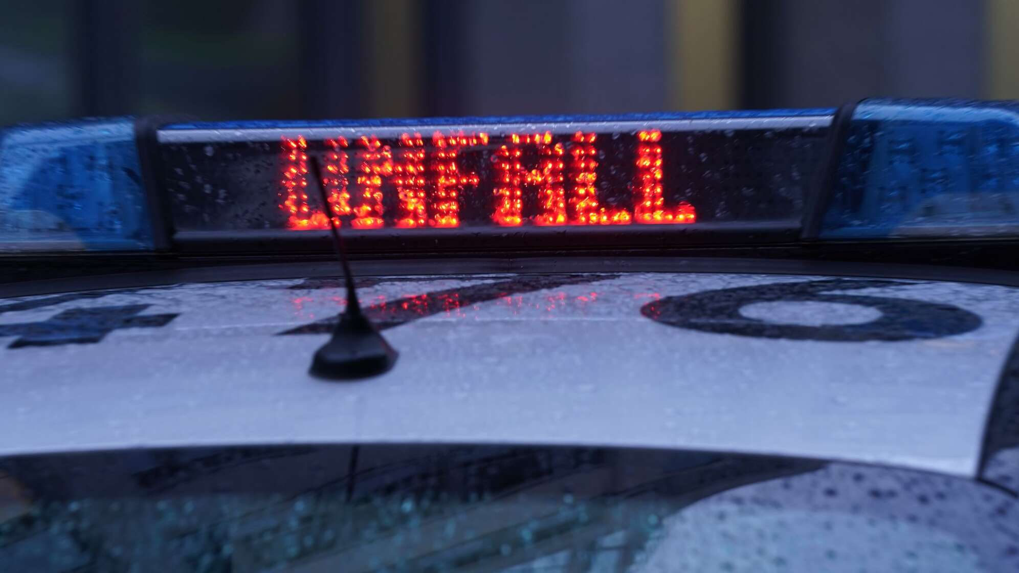 Leuchtschrift auf einem Polizeiwagen.